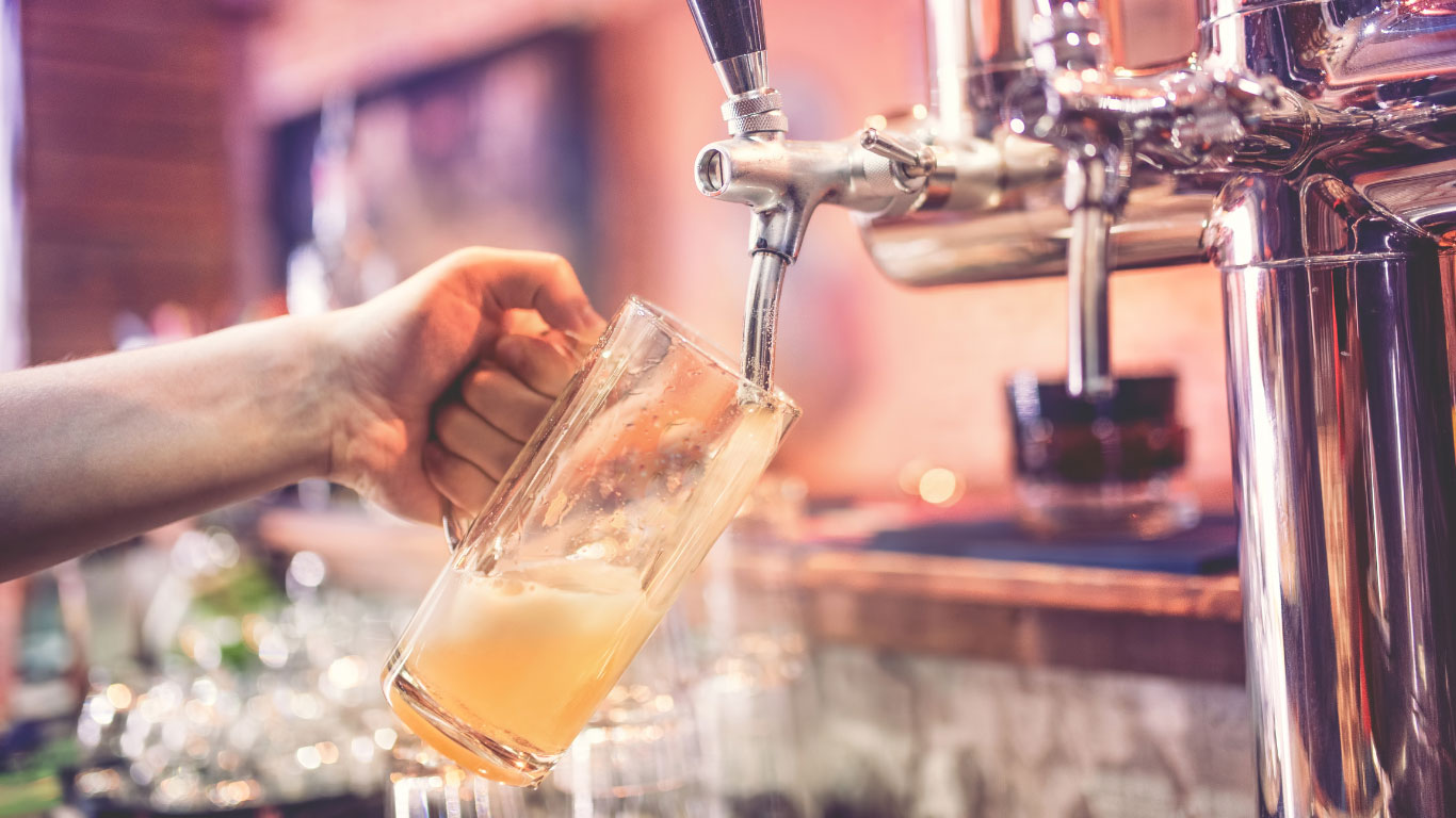 Person pouring beer from beer tap system system.